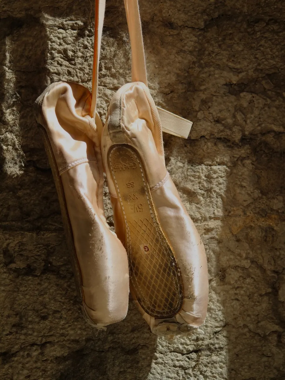 Chaussons suspendus, mur de pierre — avant la répétition
